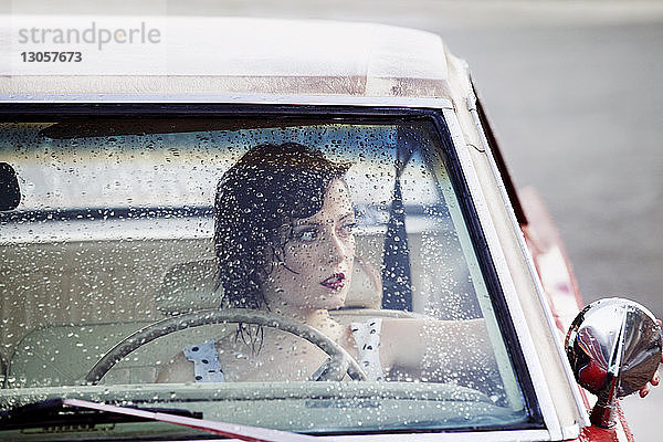 Frau schaut durch Fenster  während sie im Auto sitzt