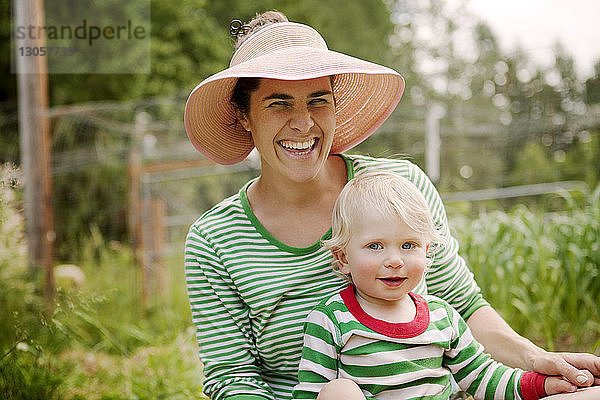 Porträt einer fröhlichen Frau mit Sohn auf dem Bauernhof