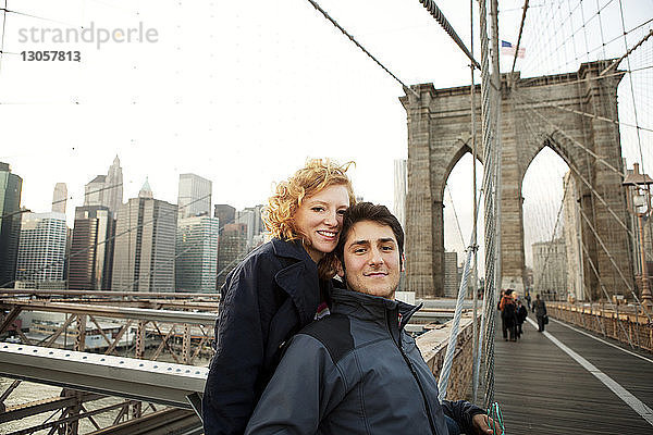 Porträt des glücklichen Paares auf der Brooklyn Bridge in der Stadt