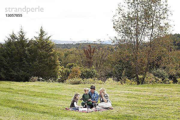 Familie geniesst Picknick auf Grasfeld