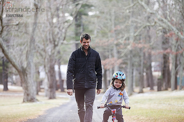 Glücklicher Vater sieht Sohn beim Radfahren auf der Straße