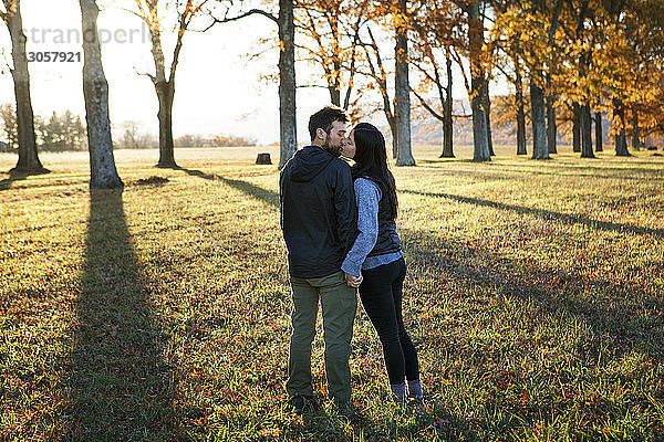 Küssende Paare im Stehen auf dem Spielfeld