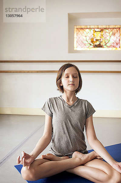 Mädchen meditiert im Yoga-Unterricht