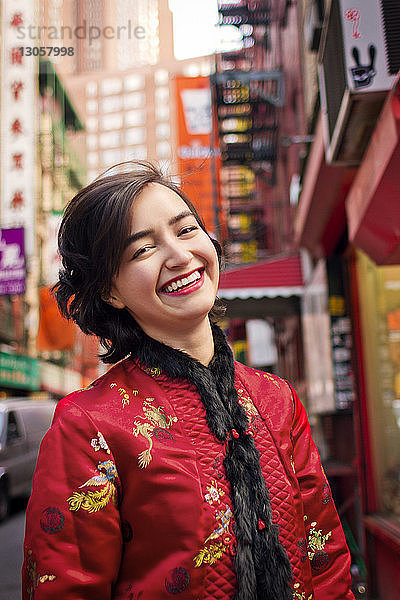 Porträt einer fröhlichen Frau in traditioneller Kleidung auf der Straße der Stadt stehend