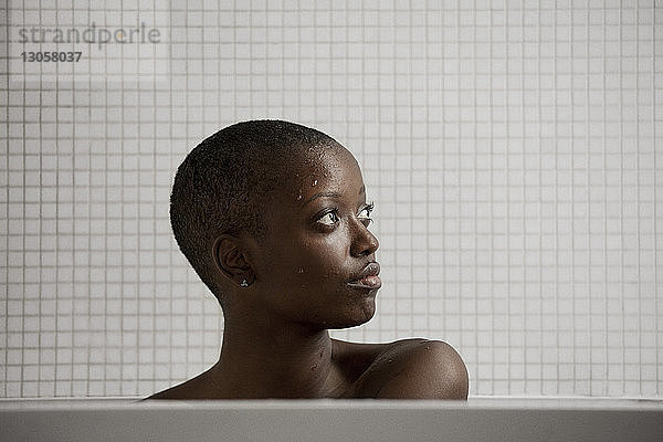 Nachdenkliche Frau badet zu Hause in der Badewanne