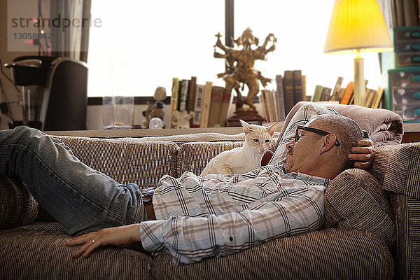 Seitenansicht eines Mannes  der sich zu Hause auf dem Sofa entspannt