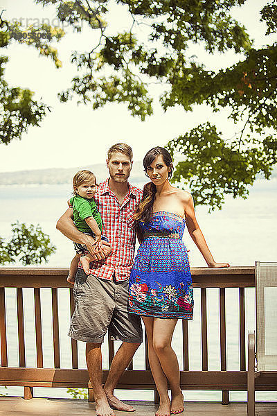 Porträt einer Familie  die am Geländer vor dem See steht