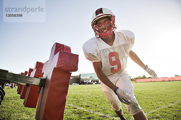 American-Football-Spieler trainiert auf Schlitten auf dem Spielfeld