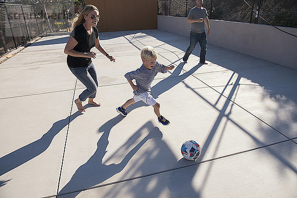 Hochwinkelansicht von Eltern und Sohn beim Fußballspielen