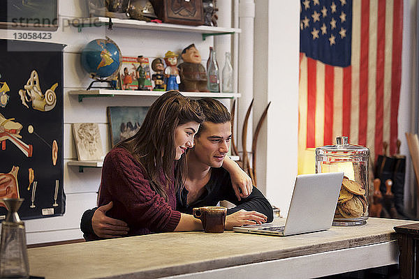 Paar benutzt Laptop-Computer  während es im Café sitzt