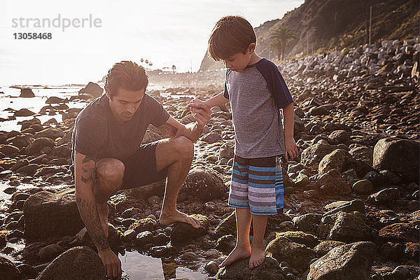 Vater und Sohn bei Sonnenuntergang am Strand