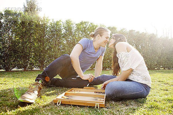 Romantisches Paar beim Backgammon-Spiel auf Rasen