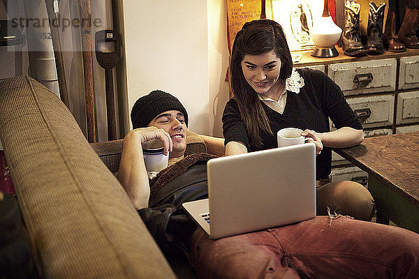 Paar benutzt Laptop-Computer  während es sich im Café entspannt