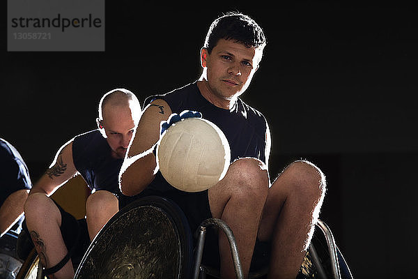 Porträt eines Mannes  der einen Ball dribbelt  während er vor Gericht Rollstuhl-Rugby spielt