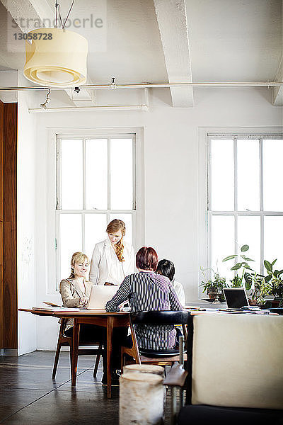 Weibliche Kollegen diskutieren am Konferenztisch im Kreativbüro