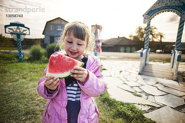 Glückliches Mädchen isst Wassermelone im Park