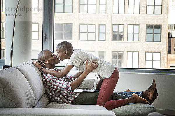 Küssende Paare  die zu Hause auf dem Sofa sitzen