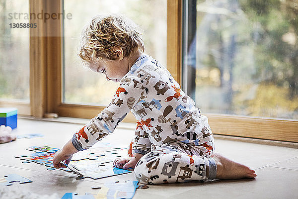 Kleiner Junge spielt zu Hause Puzzle