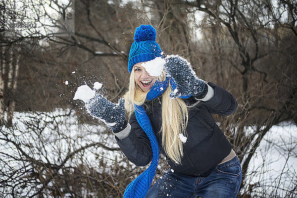 Frau spielt mit Schnee auf dem Feld