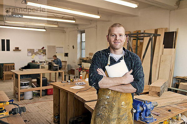 Porträt eines selbstbewussten männlichen Tischlers in der Werkstatt stehend