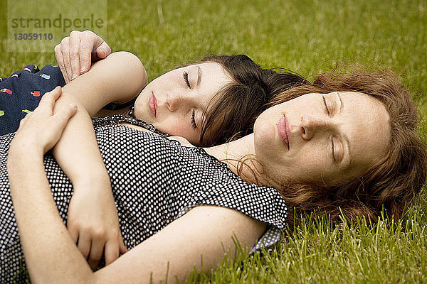 Mädchen schläft bei der Mutter im Garten