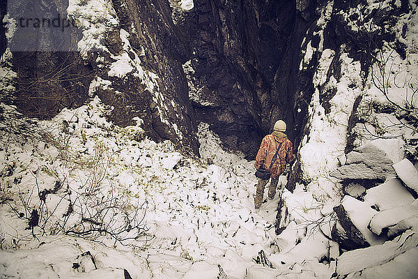 Hochwinkelaufnahme eines Mannes  der auf einem schneebedeckten Berg wandert