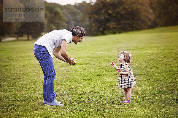 Vater spielt mit Tochter im Park