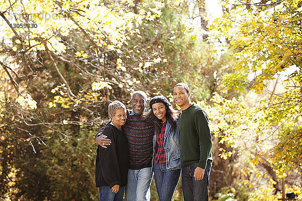 Porträt einer Familie im Wald an einem sonnigen Tag