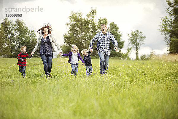 Glückliche Familie geniesst auf Grasfeld