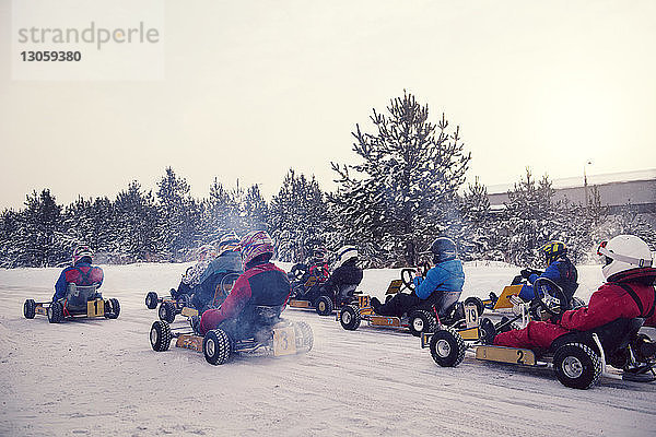 Jugendliche genießen Go-Kart-Rennen auf schneebedecktem Feld
