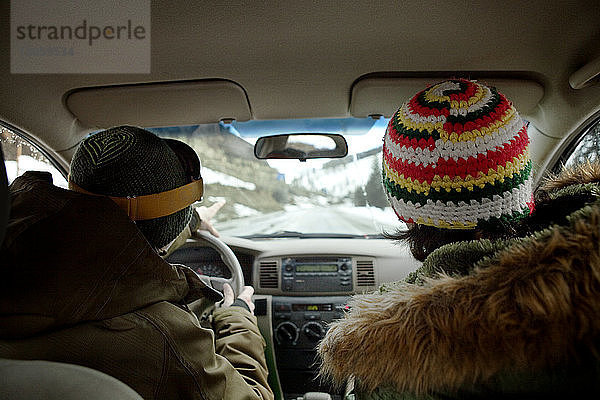 Rückansicht der im Auto sitzenden Freunde