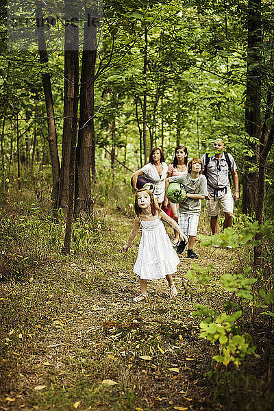 Neugieriges Mädchen mit Familie zeltet im Wald