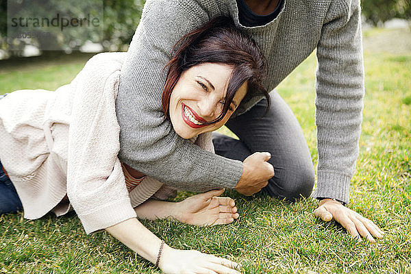 Verspieltes Paar auf Rasen im Park