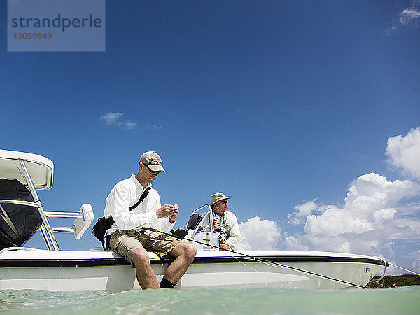 Freunde sitzen auf einem Motorboot auf See