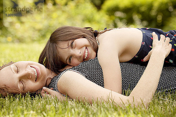 Glückliches Mädchen liegt auf der Brust der Mutter im Hinterhof