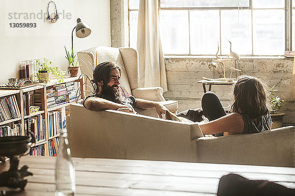 Paar redet  während es zu Hause im Wohnzimmer sitzt