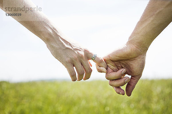 Ausgeschnittenes Bild eines Händchen haltenden Paares