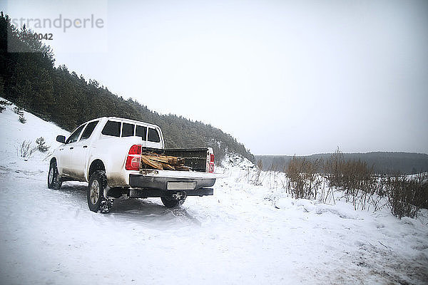 Geländewagen auf schneebedecktem Feld gegen den Himmel geparkt