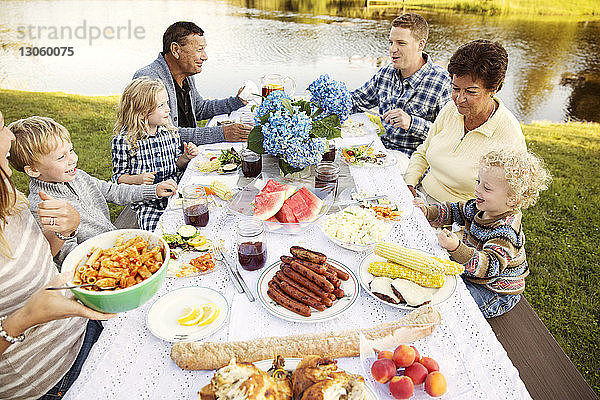 Hochwinkelansicht einer Mehrgenerationen-Familie  die auf einem Picknicktisch sitzt