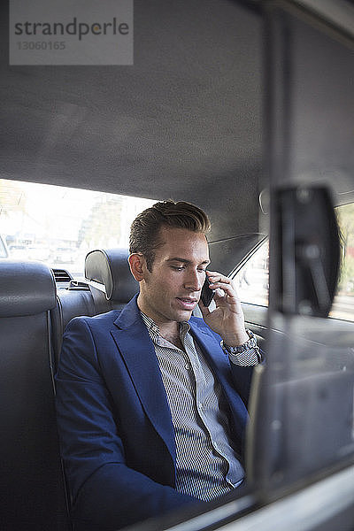 Geschäftsmann telefoniert während der Fahrt im Auto