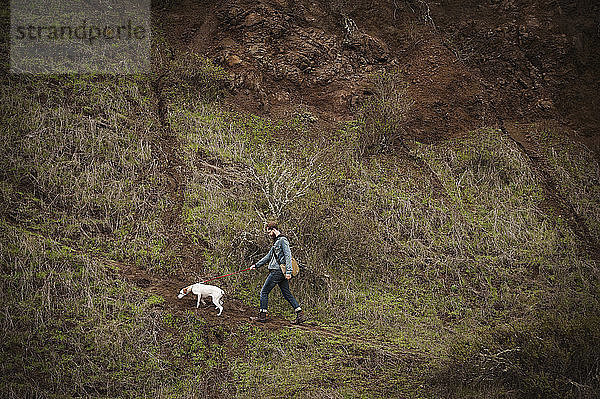 Mann mit Hund beim Waldspaziergang