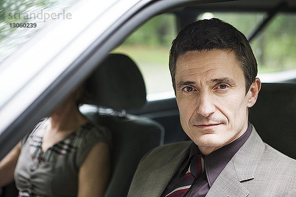 Porträt eines Mannes  der mit einer Frau im Auto sitzt