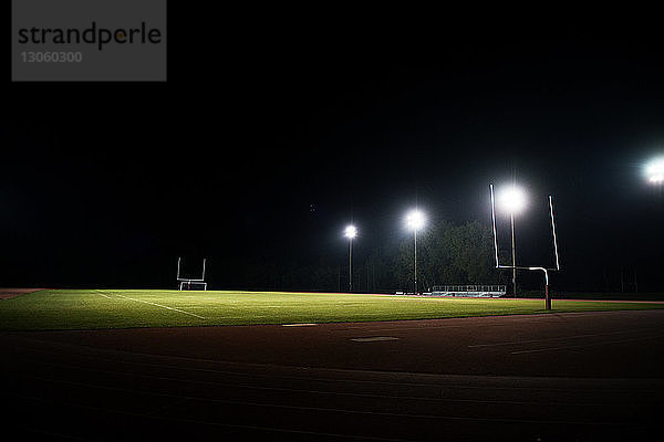 Szenische Ansicht eines beleuchteten American-Football-Feldes bei Nacht