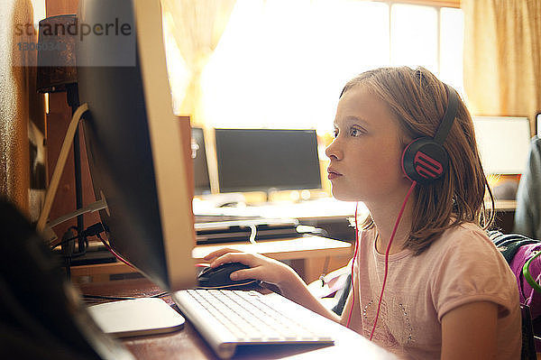 Mädchen benutzt Desktop-Computer im Computerraum
