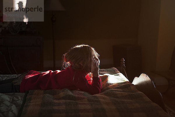 Mädchen mit Hand am Kinn  das im Schlafzimmer schläft