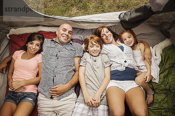 Porträtansicht einer glücklichen Familie  die sich im Zelt ausruht