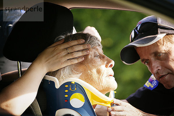 Nahaufnahme eines Sanitäters beim Anlegen einer Halskrause an einen Patienten im Auto