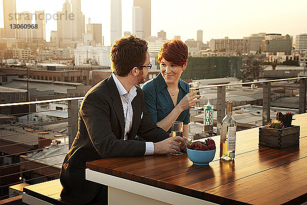 Ehepaar genießt Wein im Terrassenrestaurant bei Sonnenuntergang