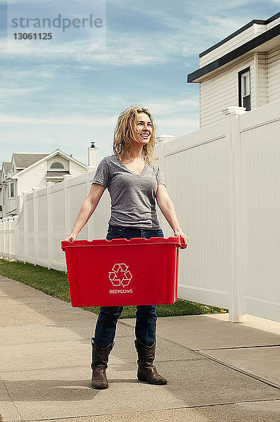 Glückliche Frau mit Recycling-Tonne