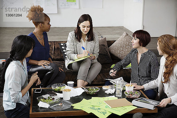 Geschäftsfrau diskutiert Strategie mit Kolleginnen im Kreativbüro